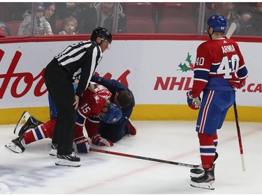 Joel Armia (40) comes in to help Jesperi Kotkaniemi (15) who is tended to after being brought down on play, during first period NHL action in Montreal on Thursday December 05, 2019.