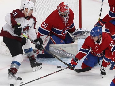 Avalanche' Matt Calvert drives the Montreal net as goalie Cayden Primeau and Matthew Peca, right, defend the action.