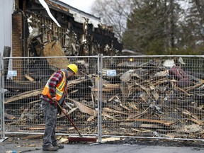 Lukas Barycza sweeps debris after a fire destroyed the offices of the West Island Assistance Fund in Pierrefonds-Roxboro.