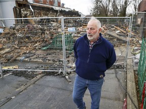 Michael Labelle, president of the board of directors of the West Island Assistance Fund, walks by rubble on Dec. 10 after a fire destroyed the offices of the community aid organization in Roxboro.