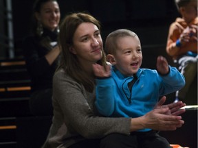 A woman and her son applaud for a performer during a night for children suffering from cancer and their families at Montreal's McCord Museum  in Montreal Saturday, December 14, 2019.