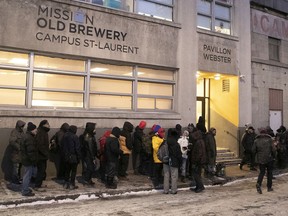 People wait for the doors to open for dinner at the Old Brewery Mission on Thursday, Dec. 19, 2019.