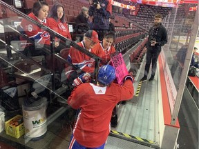 Canadiens winger Brendan Gallagher greets Theresa Martell, in Habs cap, as her daughter Denise Martell and granddaughters Breanne and Kailey look on during the Canadiens' morning skate at the Saddledome in Calgary.
