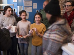 Keirra Piazza (with Mia Illuzzi, left and Sofia Illuzzi) smiles at a visitor to a special Italian-themed Christmas Eve lunch at Chez Doris in Montreal on Saturday, Dec. 21, 2019. The meal was made and served by the Illuzzi family from Rosemère, Qc.