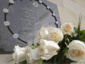 Fourteen white roses sit at the base of a memorial plaque at Ecole Polytechnique in Montreal Friday December 6, 2013, to remember 14 victims of the massacre. "As a society, we are being forced to face what women have always known: we experience violence, be it subtle and undermining, or obvious and dangerous, on a daily basis," Leona Heillig writes.