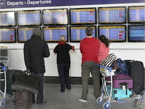 Travellers in front of the departure board at Trudeau airport.