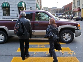 Pedestrians wait for a pick-up truck that failed to stop to let them cross the street at the crosswalk on Peel St., south of Ste-Catherine St., in Montreal in 2011.