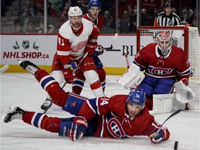 Canadiens' Nick Suzuki tips the puck away as he falls to the ice as goaltender Carey Price follows the play in Montreal on Saturday, Dec. 14, 2019.