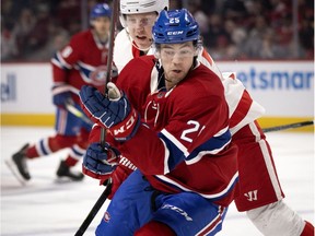 Canadiens' Ryan Poehling and Detroit Red Wings' Adam Erne chase the puck to the boards during NHL action in Montreal on Saturday, Dec. 14, 2019.