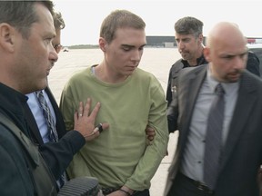 Luka Rocco Magnotta (centre) escorted by police upon arrival from Germany on June 18, 2012 at Mirabel Airport.