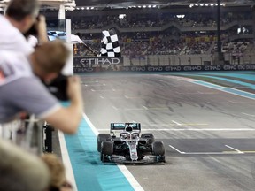 Mercedes' British driver Lewis Hamilton crosses the finish to win the final race of the Formula One Grand Prix season at the Yas Marina Circuit in Abu Dhabi, on December 1, 2019. (Photo by Luca Bruno / POOL / AFP)