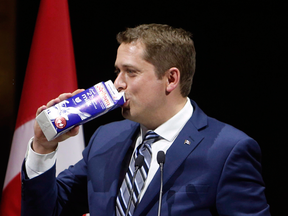 Conservative Leader Andrew Scheer drinks milk to make light of suggestions he was indebted to the dairy lobby, as he takes the stage at the National Press Gallery Dinner in Gatineau, Quebec, June 3, 2017.