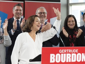 Quebec Liberal candidate in Jean-Talon Gertrude Bourdon waves at supporters while interim Quebec Liberal Leader Pierre Arcand, back centre, and Marquette MNA Enrico Ciccone look on, Oct. 29.