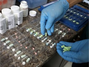 A pharmacist counts prescription drugs at an Ottawa pharmacy. Losing a paper prescription can be a serious problem for many.