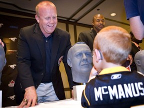 Danny McManus shares a laugh with his son Jackson following a bust unveiling ceremony as part of CFL Hall of Fame week in Calgary on Sept. 16, 2011.