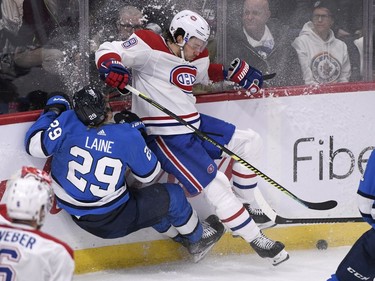 Winnipeg Jets' Patrik Laine (29) is hit by Montreal Canadiens' Ben Chiarot (8) during third period NHL action in Winnipeg on Monday Dec. 23, 2019.