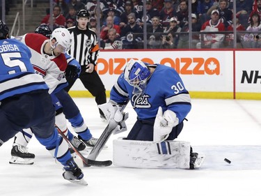 Montreal Canadiens left wing Tomas Tatar (90) scores against Winnipeg Jets goaltender Laurent Brossoit (30) in the first period at Bell MTS Place on Dec. 23, 2019.