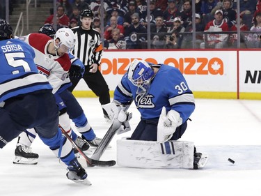 Montreal Canadiens left wing Tomas Tatar (90) scores against Winnipeg Jets goaltender Laurent Brossoit (30) in the first period at Bell MTS Place on Dec. 23, 2019.