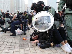 Police arrest a Hong Kong protester after a Chinese flag was removed from a flag pole at a rally in support of Xinjiang Uighurs' human rights in Hong Kong, China, December 22, 2019.