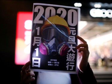 An anti-government protester holds a banner while forming a human chain protest on New Year's Eve in Hong Kong, China, December 31, 2019. REUTERS/Navesh Chitrakar