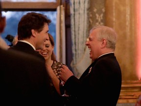 Britain's Princess Beatrice, centre background, and her father, Prince Andrew, right, share a joke with Canadian Prime Minister Justin Trudeau during a reception for the Queen's Dinner, part of the Commonwealth Heads of Government Meeting at Buckingham Palace in London on April 19, 2018.