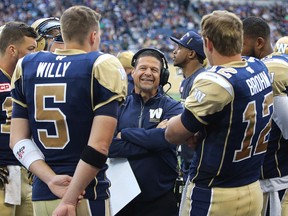 Winnipeg Blue Bombers offensive coordinator Marcel Bellefeuille, centre, speaks with, from left, quarterbacks Robert Mavre, Drew Willy, Brian Brohm and Josh Portis during CFL pre-season action against the Hamilton Tiger-Cats in Winnipeg on June 19, 2015.