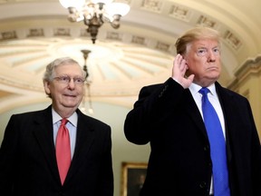 File photo: U.S. President Donald Trump listens to a question from reporters next to Senate Majority Leader Mitch McConnell (R-KY).