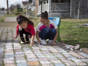 Sisters Lyhnix Baytops, 5, left, and Aubri Baytops, 8, right, draw on the sidewalk with chalk after school Thursday, Feb. 22, 2018, in Roanoke, Va. After someone gave his daughter some calcium sulphate sidewalk chalk, Joe Schwarcz found it yielded better results on the blackboard than the calcium carbonate chalk he had been using.