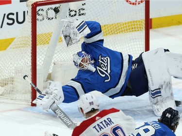 Winnipeg Jets goaltender Laurent Brossoit dives in vain in an attempt to stop a shot from Montreal Canadiens forward Tomas Tatar in Winnipeg on Mon., Dec. 23, 2019.