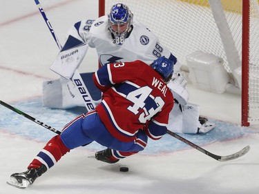 Montreal Canadiens' Jordan Weal (43) falls to the ice as he tries to get control of the puck, in front of Tampa Bay Lightning goaltender Andrei Vasilevskiy.