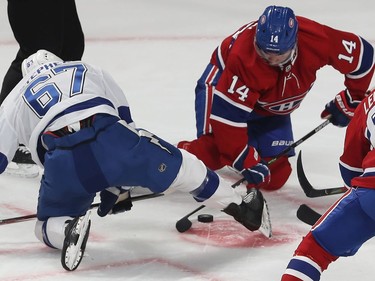 Montreal Canadiens' Nick Suzuki (14) and Tampa Bay Lightning's Mitchell Stephens (67) fall to the ice as they try to get control of the puck in Montreal on Thursday Jan. 2, 2020.