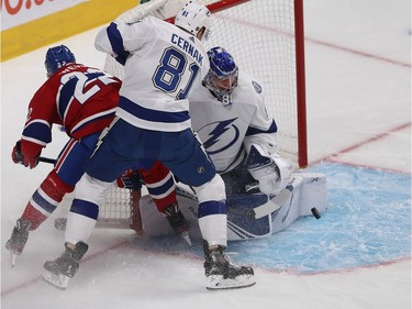 Tampa Bay Lightning goaltender Andrei Vasilevskiy pushes back the puck as Montreal Canadiens Dale Weise (22) and Tampa Bay Lightning's Erik Cernak (81) get in on the play.