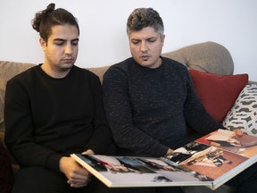 Armin Morattab, right, and his brother Arash Morattab look at family wedding album on Wednesday. The two brothers are mourning the lost of their brother Arvin, who died with his  wife, Aida Farzaneh, in the Ukraine International Airlines crash near Tehran.
