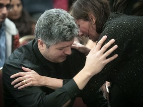 Armin Morattab, left, brother of Arvin Morattab a passenger in the ill fated flight PS752, receives condolences from a person attending memorial service for the families of the passengers that where lost in the flight during services in Montreal on Sunday January 12, 2020.