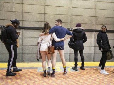 A couple of participants of the annual No Pants Day are watched as they wait on the métro platform in Montreal on Sunday, Jan. 12, 2020.