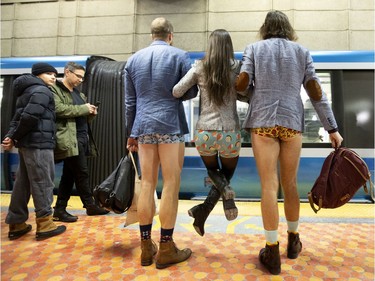 A participant of the annual No Pants Day gets a lift up as they wait on the platform for an incoming ride in Montreal on Sunday, Jan. 12, 2020.