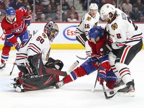 Canadiens' Artturi Lehkonen is knocked off the puck by Blackhawks defenceman Duncan Keith in front of Chicago goalie Corey Crawford during January 2020 game at the Bell Centre.