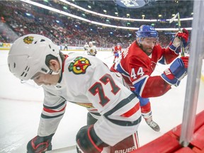Canadiens' Nate Thompson throws a check at Blackhawks' Kirby Dach during third period Wednesday night at the Bell Centre.