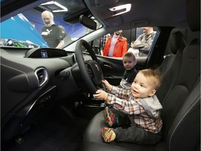 Fifteen-month-old Félix Gauthier checks out a 2020 Prius Prime, a plug-in hybrid, at the Montreal International Auto Show on Saturday, Jan. 18, 2020.