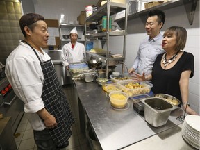 Owners Eva Lau and Joe Zhou speak to chef Yu Fai Kiang, left, and sous-chef Jing Feng Chen in the kitchen of their new 31º Latitude restaurant in Montreal.