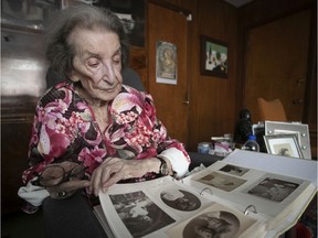 Liselotte Ivry, who survived Auschwitz, goes though some of the old pictures she has kept, at her home on Thursday, Jan. 23, 2020.