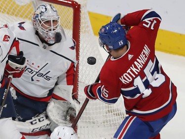 Montreal Canadiens' Jesperi Kotkaniemi (15) looks at flying puck in front of Washington Capitals goaltender Braden Holtby.