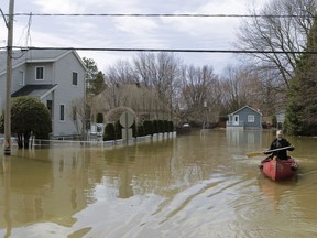 A man canoes in Ste-Marthe-sur-le-Lac on April 28, 2019, the day after the Lake of Two Mountains breached a dike in the community.