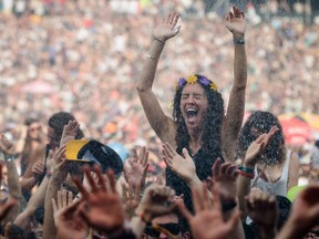 Music fans are sprayed with water as they enjoy the performance by Scottish electronic band CHVRCHES at the 2014 Osheaga Music Festival at Jean-Drapeau Park in 2014.