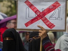 Zakia Khan holds a sign  at a rally that teachers organized against Bill 21 in Montreal Saturday, September 28, 2019 outside the Parc metro station.