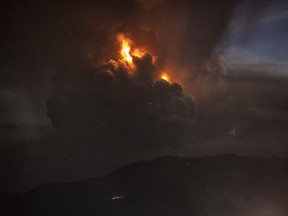A column of ash surrounds the crater of Taal Volcano as it erupts on Sunday, Jan. 12, 2020, as seen from Tagaytay city, Cavite province, Philippines.
