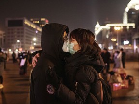 A Chinese couple wearing their protective masks kiss before saying goodbye in Beijing Station Jan. 22, 2020.