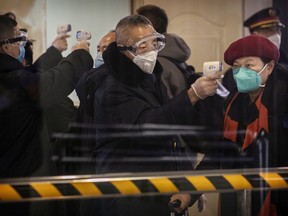 A Chinese passenger that just arrived on the last bullet train from Wuhan to Beijing is checked for a fever by a health worker at a Beijing railway station on January 23, 2020 in Beijing, China. The number of cases of a deadly new coronavirus rose to over 500 in mainland China Wednesday as health officials locked down the city of Wuhan in an effort to contain the spread of the pneumonia-like disease which medicals experts have been confirmed can be passed from human to human. In an unprecedented move, Chinese authorities put travel restrictions on the city of 11 million and two other neighbouring cities preventing people from leaving after 10 AM local time Thursday. The number of those who have died from the virus in China climbed to at least 17 on Thursday and cases have been reported in other countries including the United States,Thailand, Japan, Taiwan and South Korea.