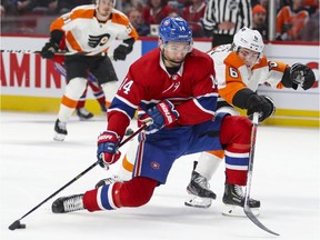 Canadiens' Nick Suzuki protects the puck from Flyers' Travis Sanheim  during game at the Bell Centre in November.