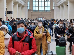 Commuters wear face masks as they wait at a train station in Wuhan, China.